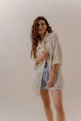 Saco calado negro tejido a máquina, con cuello tipo camisa y mangas 3/4.