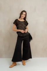 Pantalón de pierna ancha con tiro medio, confeccionado en brin de algodón con spandex. Presenta costuras a contratono que resaltan su diseño y bolsillos laterales.