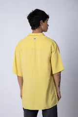 Camisa de manga corta con cuello cubano, confeccionada en fibrana premium. Presenta un corte oversize y cierre frontal con botones al tono.