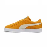 Championes Puma Suede Classic color mostaza con franja lateral blanca y suela blanca.