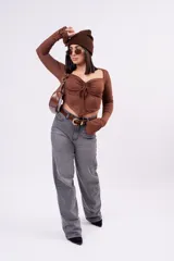 Crop top de manga larga color marrón, confeccionado en tela elastizada suave, con escote corazón, frunce ajustable en el centro del pecho, diseño inferior en pico y mangas largas con puños acampanados.
