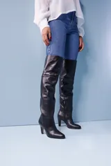 Bota de cuero negra con caña alta, taco fino y cierre lateral.