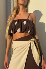 Top corto tipo balloon de color marrón con estampado de grandes lunares blancos, breteles finos y diseño abullonado con elástico.