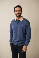 Buzo de manga larga estilo rugby color azul petróleo, con cuello beige en contraste, tapeta con botones y pequeño bordado en el pecho. Confeccionado en algodón pesado con fit relajado.