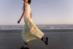 Sandalias bajas de cuero color marrón, con tiras finas para atar alrededor del tobillo.