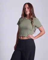 Remera de morley de algodón color verde oliva, de corte ajustado y estilo crop top, con mangas cortas y terminaciones con borde fruncido.