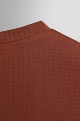 Camiseta deportiva color durazno de manga larga con orificios para los pulgares.