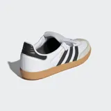 Championes Adidas Samba LT de diseño retro, confeccionados en cuero de primera calidad con puntera de nobuk. Presentan las icónicas tres bandas laterales en negro, suela de goma color caramelo y una lengüeta extragrande inspirada en las botas de fútbol clásicas.
