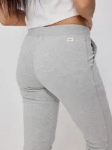 Pantalón deportivo tipo jogging color gris melange, confeccionado en 60% algodón y 40% poliéster, con cintura elástica ajustable con cordón y puños ajustados con cierre.