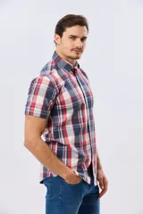 Camisa de manga corta con estampado de cuadros en tonos celestes, azules, blancos y verdes, con cierre frontal de botones y bolsillo ojal en el pecho.