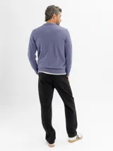 Buzo tejido de punto color beige, con cuello polo y escote en V profundo, de manga larga con puños acanalados.