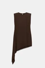 Vestido corto de color marrón, con cuello redondo y diseño sin mangas. Presenta un bajo asimétrico con un lateral más largo y cierre en la espalda con abertura y botón.