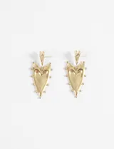 Par de aros colgantes de acero quirúrgico hipoalergénico, color dorado. El dije principal tiene forma de corazón alargado con borde decorado con pequeñas esferas. El gancho superior es una pequeña forma de corazón.