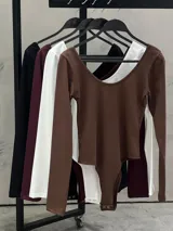 Body de manga larga en color negro, con escote cuadrado amplio y ajuste al cuerpo.