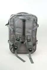 Mochila gris de poliéster, con compartimento principal con cierre, bolsillo frontal con cierre y bolsillo vertical en el frente.