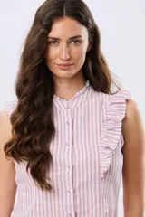 Musculosa de lino rayada con cuello mao y volados en los hombros. Presenta diseño de rayas verticales y aplique de etiqueta con logo en la parte posterior.