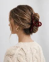 Pinza de pelo color bordó con diseño abierto y entrelazado, ideal para recoger el cabello.
