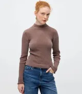 Blusa de chenille color beige, con cuello alto y diseño ajustado al cuerpo. Presenta mangas largas y una textura acanalada en toda la prenda.
