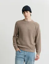Sweater de punto inglés con escote redondo y mangas largas. Presenta cuello y puños terminados en punto canalé.