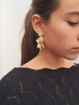 Aros colgantes con forma de hojas en color blanco y dorado, con base cuadrada dorada. Hechos a mano con plástico reciclado.