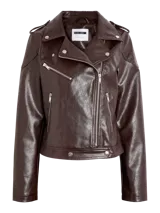 Campera biker negra de cuero sintético con solapas anchas, cierre frontal cruzado, bolsillos con cremallera y detalles metálicos.