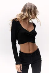 Top negro de lurex con escote cuadrado cruzado y mangas largas.