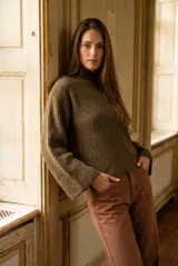 Polera de lana verde militar con tejido acanalado, cuello alto, mangas largas holgadas y corte oversize.