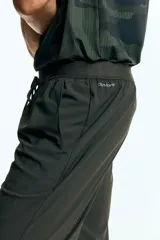 Pantalón deportivo de corte ajustado (slim fit) en tejido funcional DryMove™ color verde oscuro, con cintura elástica y cordón de ajuste oculto. Posee bolsillos al bies y piernas levemente ajustadas.