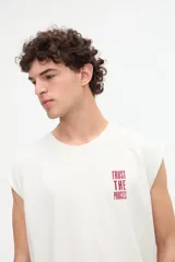 Musculosa gris oscuro con efecto lavado, corte relaxed y estampa en la espalda con la frase "Beyond the noise find your signal" en tono bordó.