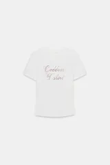 Camiseta blanca de corte slim fit, cuello redondo y manga corta. Estampado frontal con la frase 'Goddess T-shirt' en strass color rosa. 