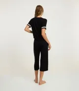 Conjunto de pijama femenino de dos piezas, compuesto por una blusa de manga corta con detalle de encaje en mangas y cuello, abotonada al frente, y un pantalón capri. Ambas prendas son de viscosa certificada.