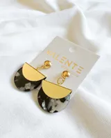 Par de aros colgantes con forma semicircular, compuestos por una pieza superior dorada y una pieza inferior con diseño marmolado en tonos blanco y negro.