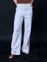 Jean de tiro alto con corte wide leg, color blanco. Presenta pretina con pasadores, cierre frontal con botón y bolsillos funcionales tanto en la parte delantera como en la trasera.
