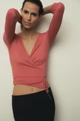 Camiseta de algodón Supima con diseño cruzado, escote en pico y cierre frontal ajustable mediante lazadas laterales. Presenta corte ajustado y manga larga.