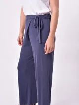 Pantalón palazzo azul oscuro con textura de canalé, cintura alta y lazo ajustable en la parte delantera.