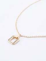 Cadena fina de eslabones con dije geométrico rectangular en tono dorado.