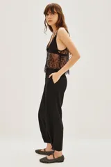 Pantalon de vestir negro de corte sastrero, con tiro medio, bolsillos laterales y botamanga con detalle de botón.