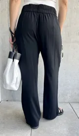 Pantalón negro de lino de corte holgado, con cintura alta y cierre con doble botón.