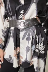 Cinto de cuero con elástico, en color tostado metalizado, con hebilla ovalada metálica. Se ajusta hasta una medida de 1.20 cm.