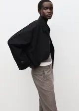 Pantalón de vestir color gris con sutil patrón a cuadros, de corte recto y tiro medio con bolsillos laterales.