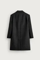 Abrigo regular fit de color negro, confeccionado con mezcla de lana y cashmere. Presenta cuello con solapas de muesca, manga larga, bolsillos de vivo en la cadera, abertura central en la espalda y cierre frontal de botonadura con tres botones.