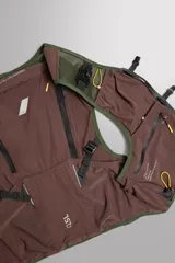 Chaleco deportivo técnico de malla transpirable en color negro, diseñado para running y actividades al aire libre. Cuenta con múltiples compartimentos, bolsillos con cremalleras termoselladas, cierres frontales de hebilla de liberación rápida y ajuste lumbar mediante cordón elástico.