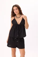 Top negro con breteles finos, escote en V profundo y ajuste frontal con botones.