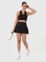 Top deportivo tipo polo de corte cropped, con cuello clásico y escote en V. Presenta un diseño ajustado al cuerpo y espalda estilo nadadora.