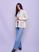Campera de lana color crudo con cierre frontal, cuello alto y bolsillos frontales aplicados en tono beige. Presenta un diseño estructurado con espalda en paño.