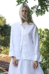 Camisa de corte clásico confeccionada en lino, con cuello camisero, cierre frontal de botones y mangas largas con puños.