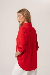 Camisa clásica de manga larga en color bordó, confeccionada en tela ligera con caída fluida, cuello camisero y cierre frontal con botones al tono.