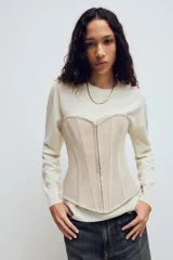 Top estilo corset de escote corazón y hombros descubiertos, con varillas interiores para estructura. Presenta cierre frontal con ganchos metálicos y ajuste posterior mediante cordones cruzados.