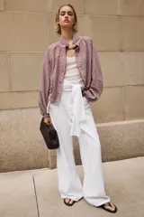 Chaqueta de manga larga con estampado de cuadros vichy en tonos marrón y blanco, cuello camisero, cierre frontal con botones y bajo ajustable con cordón.