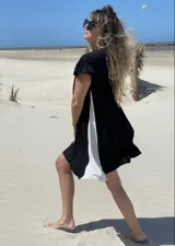 Vestido corto negro con panel lateral blanco, de corte holgado y mangas cortas con volados.